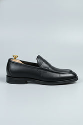 Black leather loafer with textured finish, ideal for formal and casual occasions.